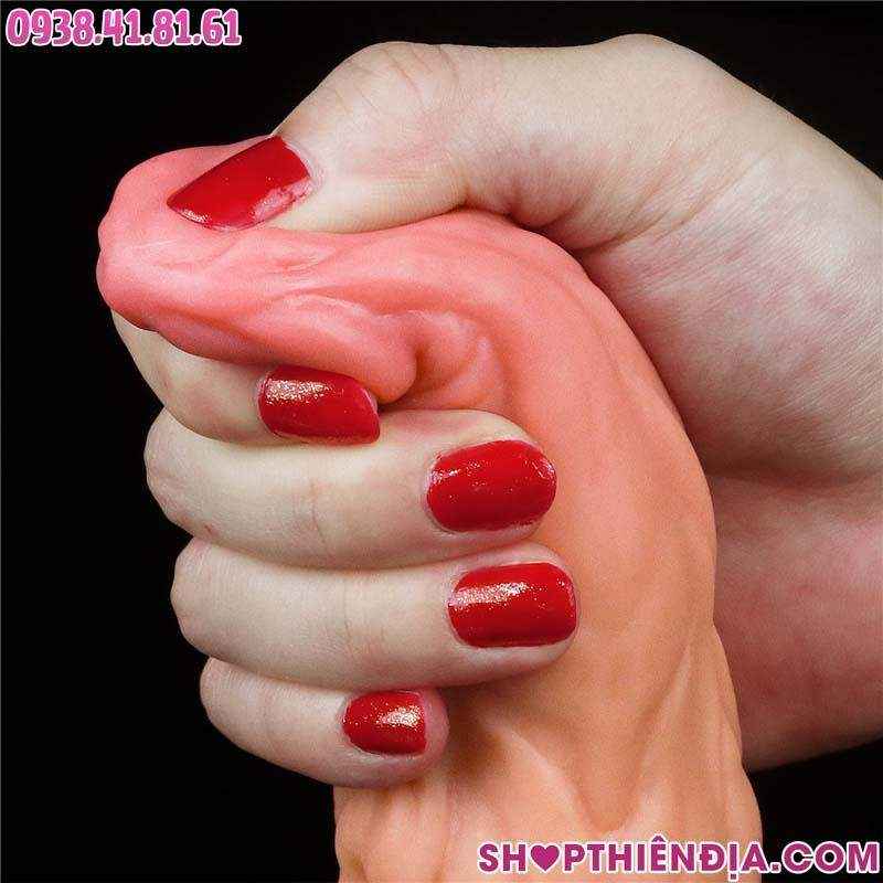 Dùng tay phải bóp phần đầu của dương vật giả khủng siêu gân Behimos